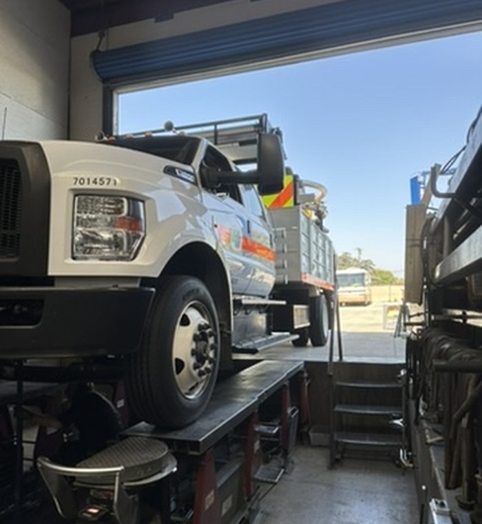 Work truck up on Pruett's alignment lift in the bay